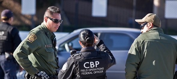 CBP officers discussing U.S. entry waiver issues at the border checkpoint - U.S. Entry Waiver Services Ltd.